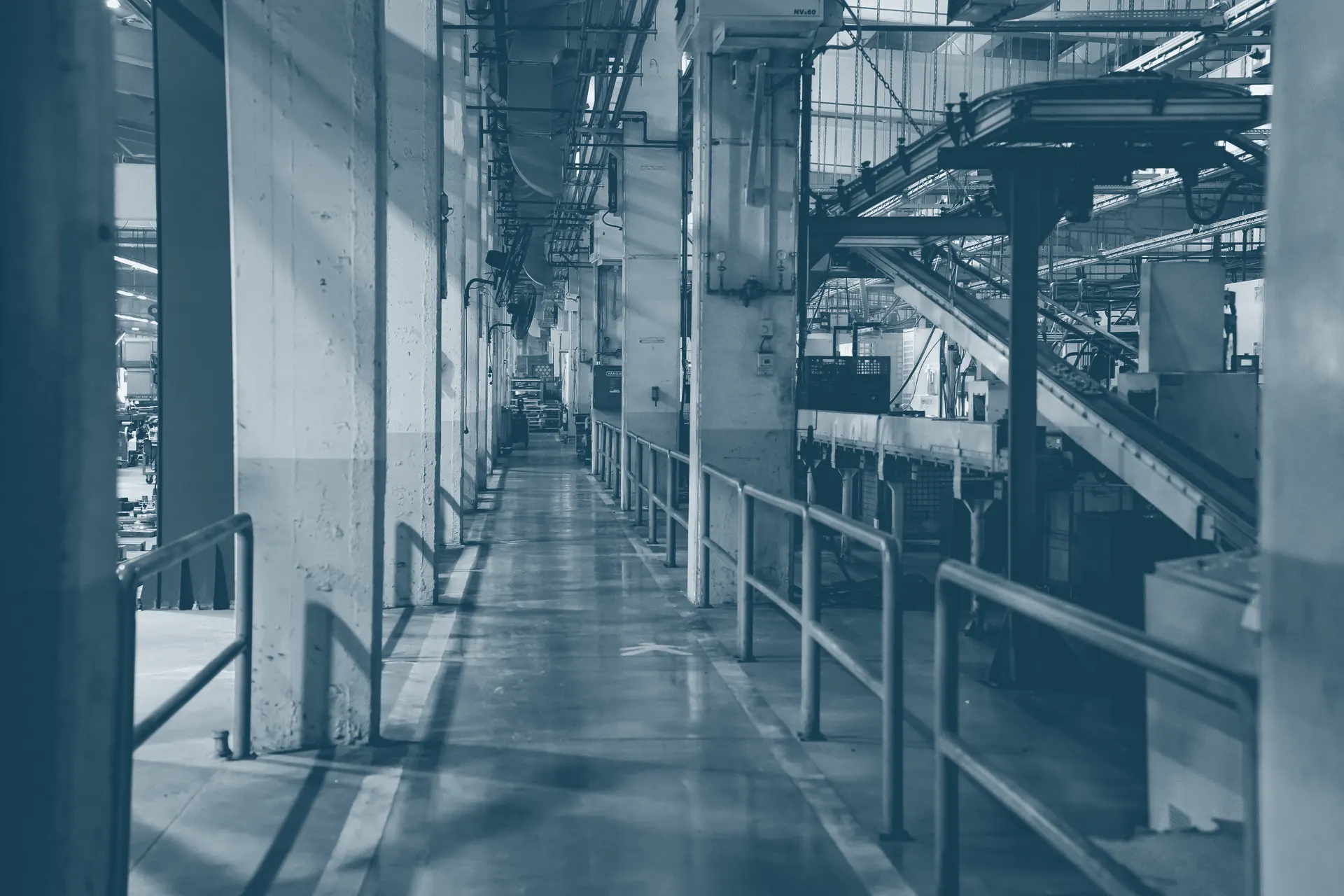 Interior de fábrica com esteira transportadora ao longo da linha de produção.